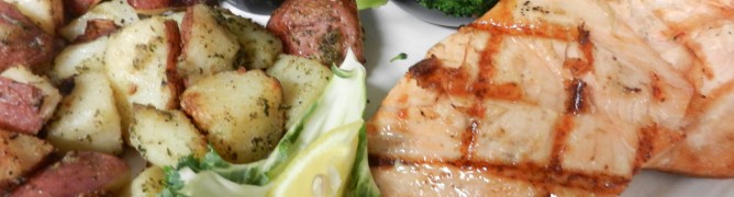 Grilled chicken with roasted potatoes, steamed broccoli, and mustard sauce.